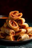 Pizza-Schnecken auf einem Teller angerichtet.